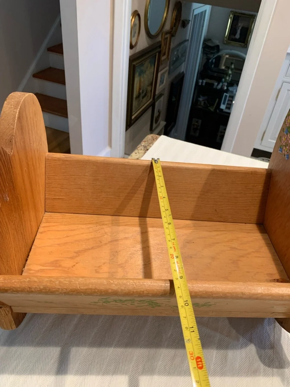Vintage wooden doll cradle heart-shaped design painted with floral details.